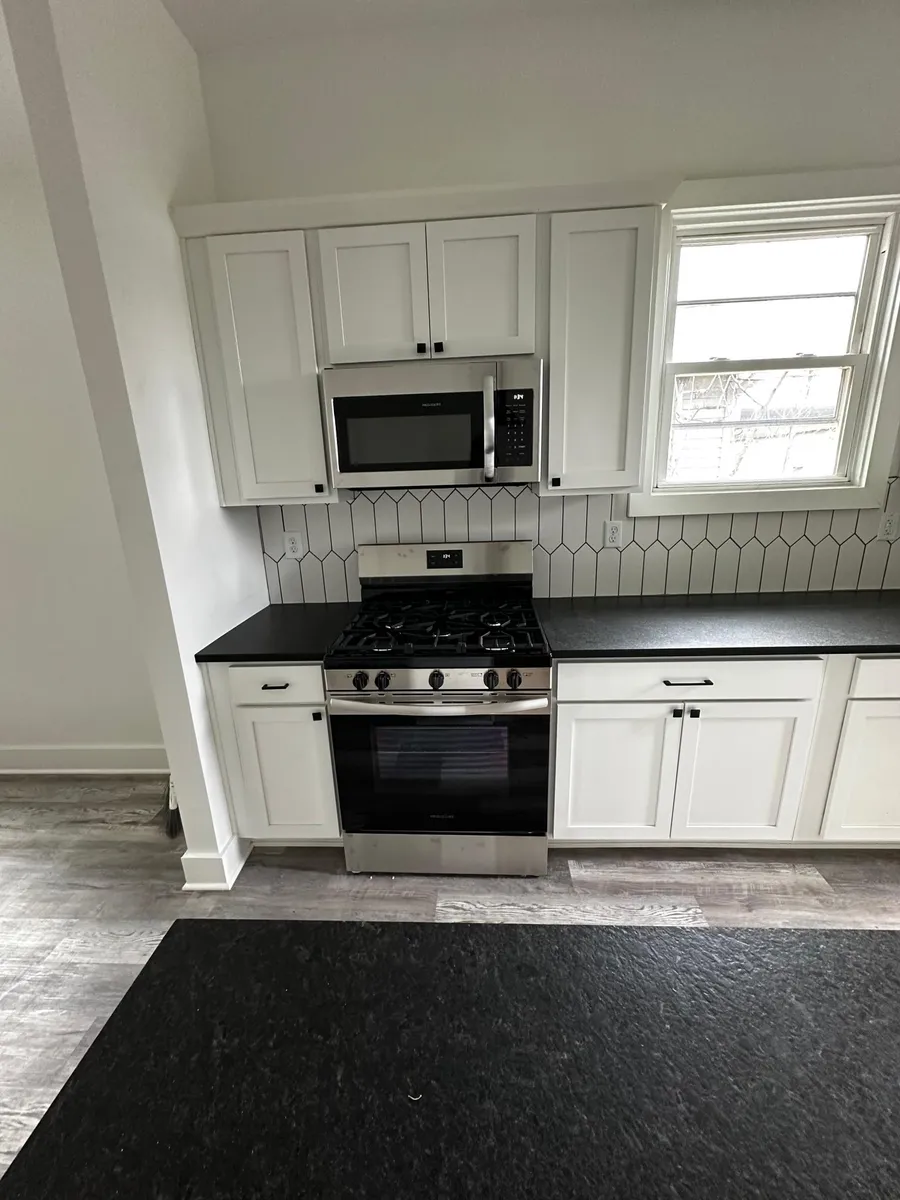 Freshly renovated kitchen with granite countertops, tile backsplash and stainless steel appliances. - 333 E Caven St