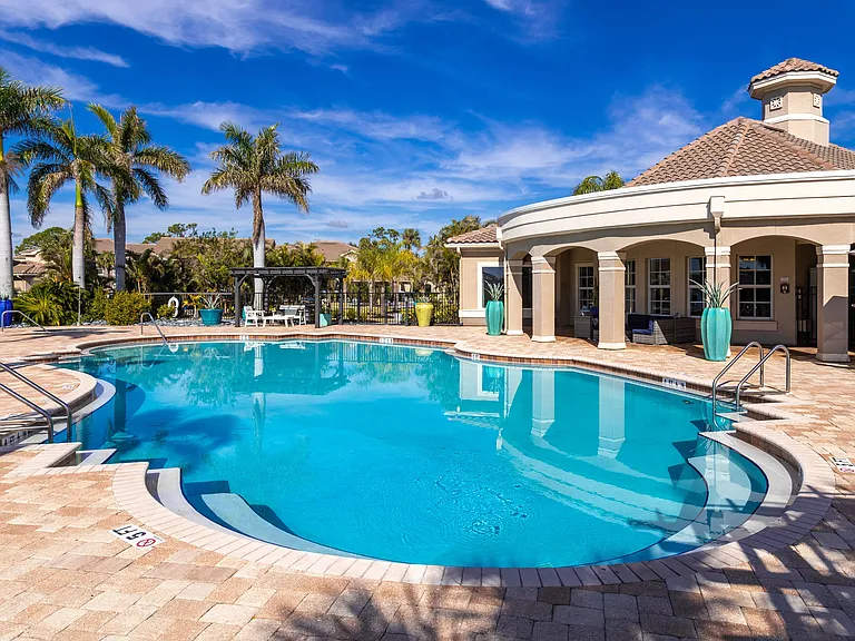 Enjoy the perfect poolside escape with an expansive sundeck, lounge seating, and lush greenery.