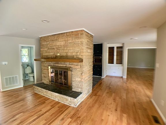 Beautiful stone fireplace is the centerpiece of this living space. Built-in China cabinet for additional storage. View of entry to den/bonus room.