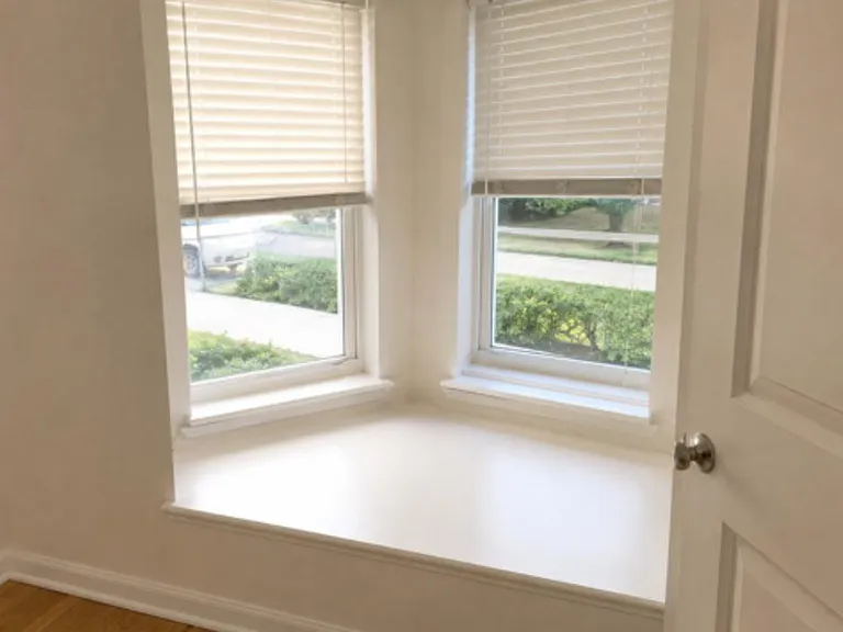 Bay-style window nook with dual windows and a wide ledge, offering a pleasant street view and space for a reading seat.