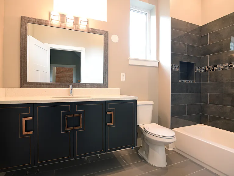 Second floor hall bath quartz countertops over unique floating cabinets.