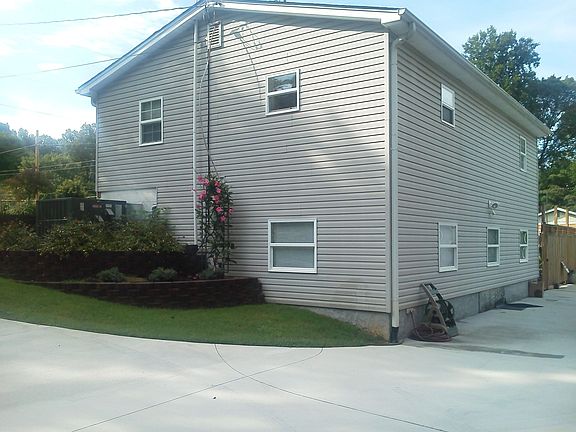 Back of home and huge concrete driveway