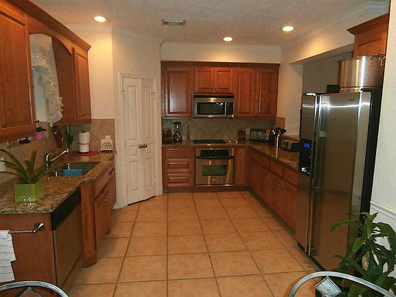 Large kitchen with stainless steel appliances and tile floor.