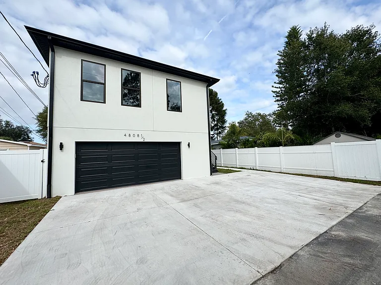 Unit is located above the garage. (Note the in-garage spaces are for the tenants of the duplex at the front of the property. Apartment tenants use the two driveway spots to the right.)