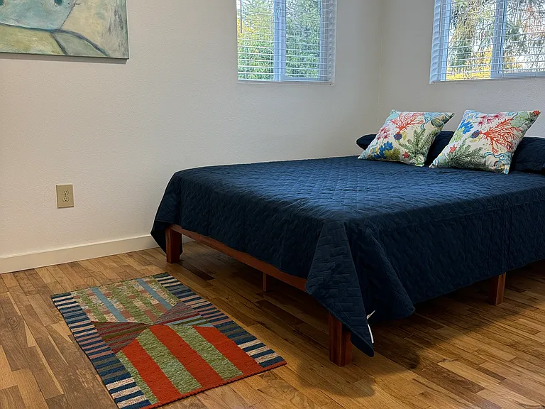 Main bedroom with nice queen mattress, all fresh linens and covers, vanity table on the the opposite wall.
