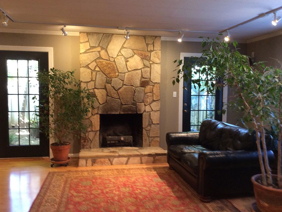 Living room with stone fireplace with gas logs