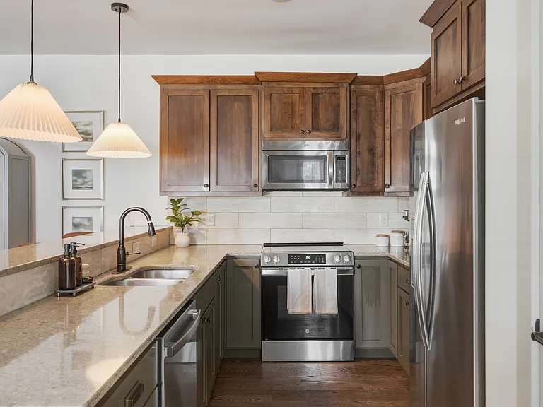 Fully equipped kitchen with stainless steel appliances. Bar countertop includes seating for 4.
