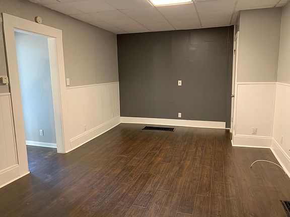 Very large living room with freshly painted walls and brand new flooring.