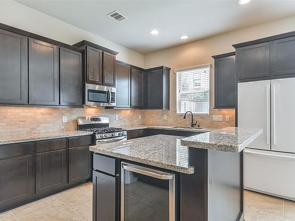Another view of the island kitchen with breakfast bar and wine fridge!