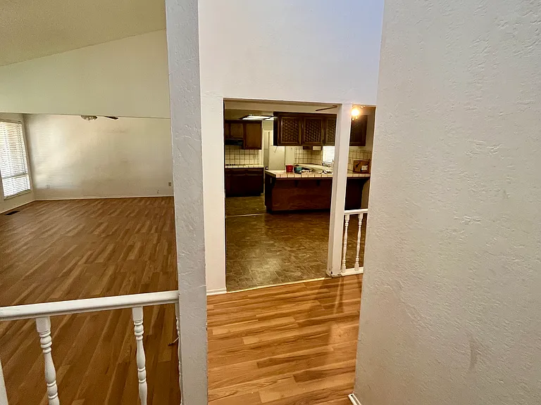 Entrance, hallway, living and dining rooms, and kitchen in the background.