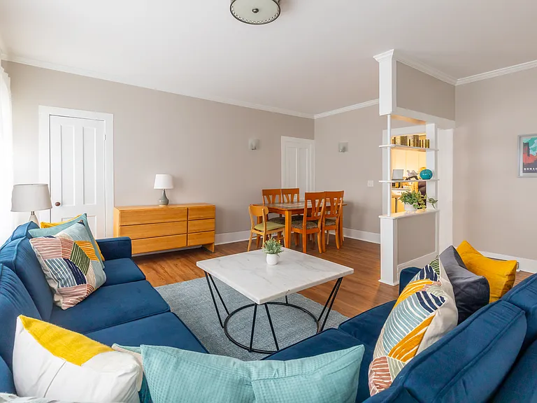 Living room has 3 separate spaces. There's now a large tv on the dresser in the photo. The dining area is just outside the kitchen door. The open are on the right of the photo now has a desk, but could be used in other ways.