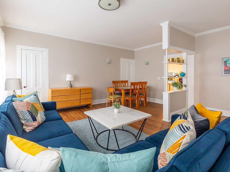 Living room has 3 separate spaces. There's now a large tv on the dresser in the photo. The dining area is just outside the kitchen door. The open are on the right of the photo now has a desk, but could be used in other ways.