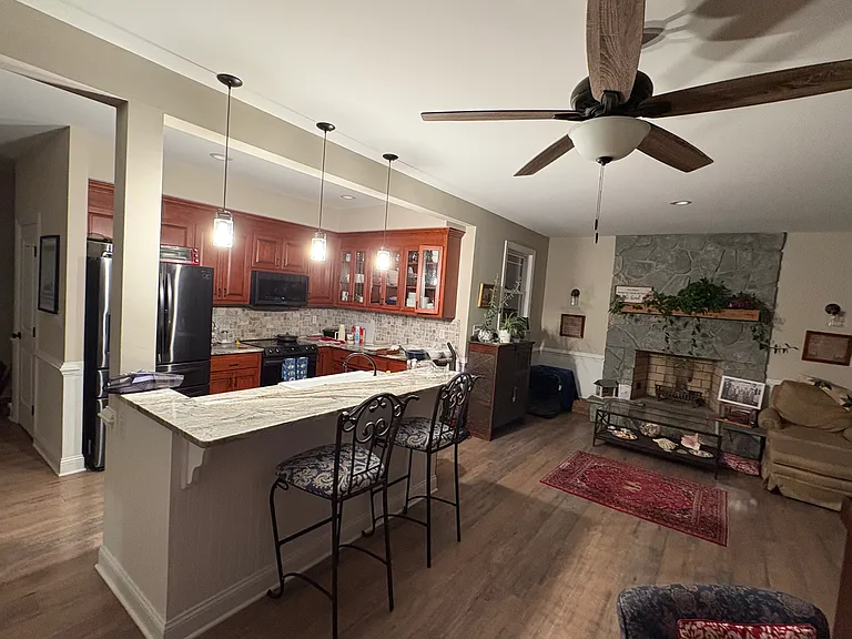 The kitchen opens to the living room and includes a bar height counter for conversation and seating.
