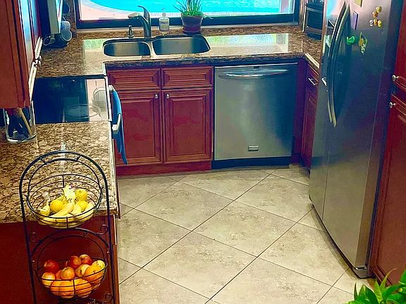 Modern kitchen has stainless steel appliances and a pass-through window for ease of outdoor entertaining.