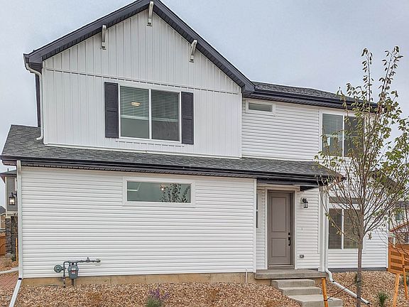 Landscaping is included. Shrubs, river rock and grass make up the front yard.