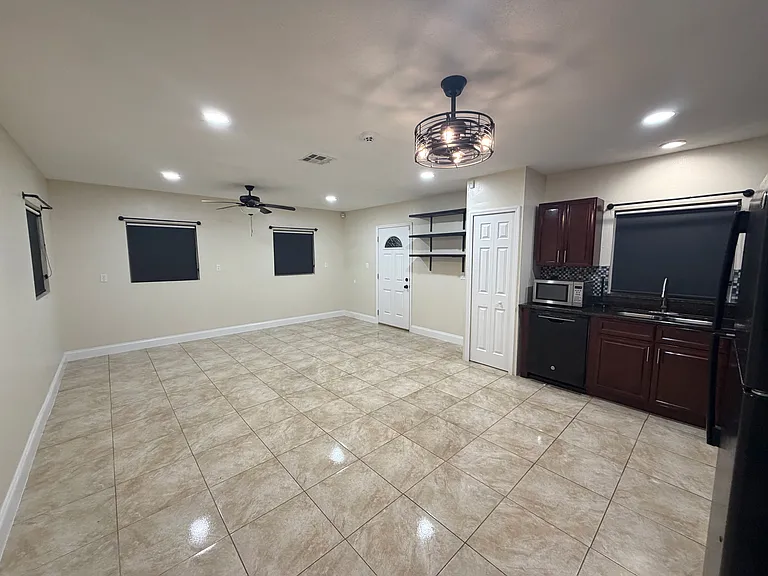 The open_concept living room offers bright windows with blackout shades and warm recessed lighting throughout the space. (Angle 4)