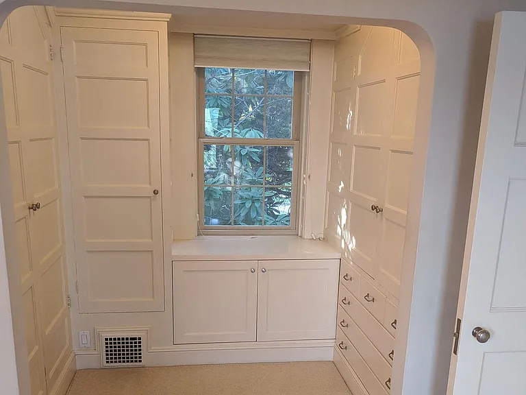 Dressing room's multiple closets and bureaus. Solid core door has built in mirror on reverse side