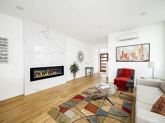 The fireplace in the living room with wood flooring and open concept floor plan is suitable to today's lifestyle!