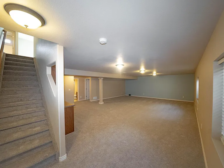 Have gone downstairs - looking up the stairs - wet bar by stairwell - entry to one BR next to the far post - next photo from the far-right corner