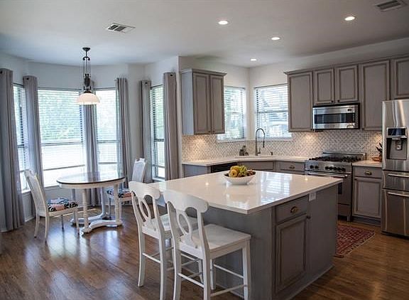 Large breakfast nook with retro styled pull down light fixture to adjust height.   Marble tile backsplash, high end stainless appliances!  Gas cook stove and oven.  Light and bright!