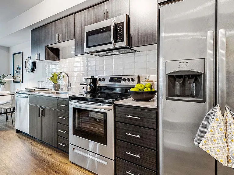 Griffis Shoreline apartment kitchen with quartz countertops and stainless steel appliances.