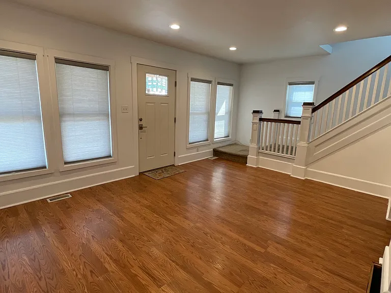 Large open living room with hardwood floors, recessed lighting, and flexible space for multiple furniture layouts.