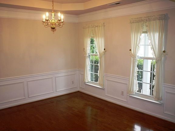 Dining room with hardwood floors, tray ceiling, heavy molding & applied panels