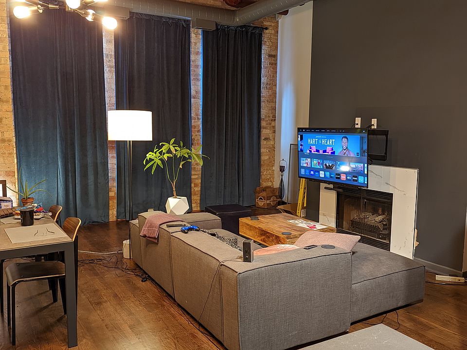 Living room has blackout curtains over large windows. The TV mount pulls down for easy viewing but can also be flush with the wall.