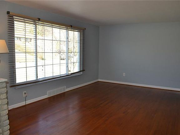 Living room has original hardwood flooring and a huge, picture window to allow a lot of natural light.  This freshly painted hom