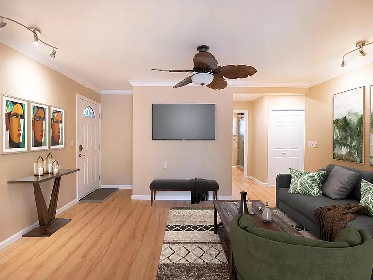 Living room with 65 inch mounted TV two fans furnished