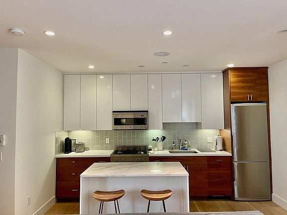Beautiful kitchen with quartz-stone counters and island, custom kitchen cabinetry, and state-of-the-art stainless steel appliances (Bertazzoni gas stovetop, oven, and microwave; Bosch refrigerator and dishwasher)