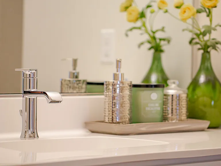 Chrome fixtures and quartz countertops in the bathrooms