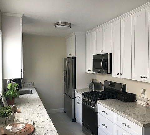 Remodeled kitchen with quartz countertops, French door refrigerator, gas stove, microwave, dishwasher