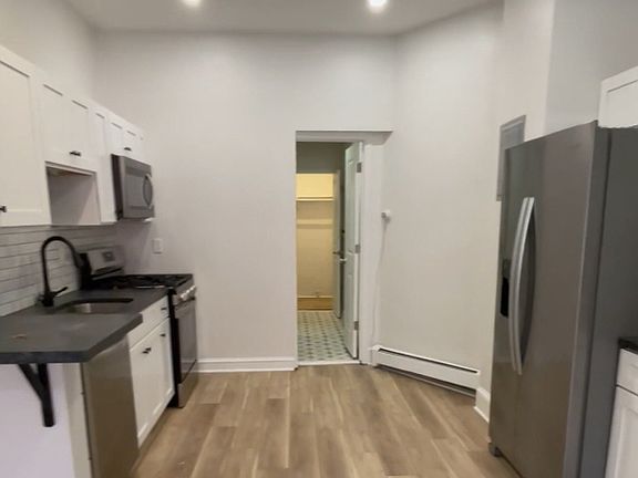 Kitchen looking into bathroom and walk in closet
