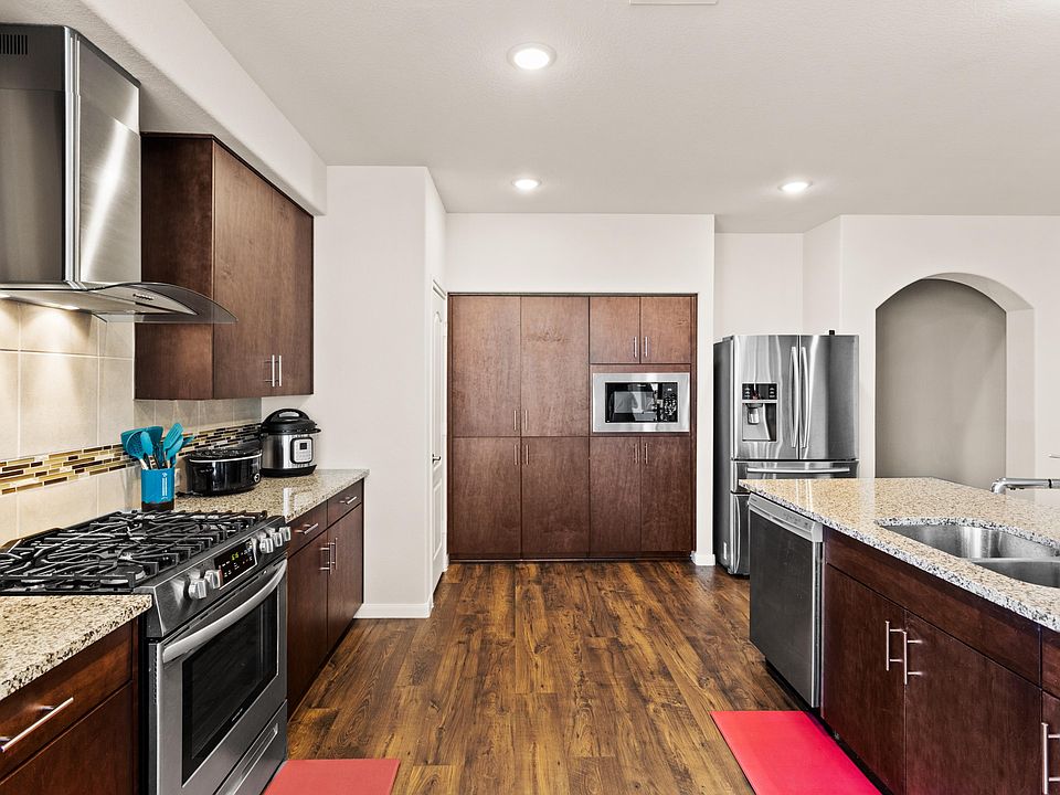 Spacious kitchen with granite countertops, ample cabinetry, gas range, built-in microwave, and stainless fridge plus dishwash