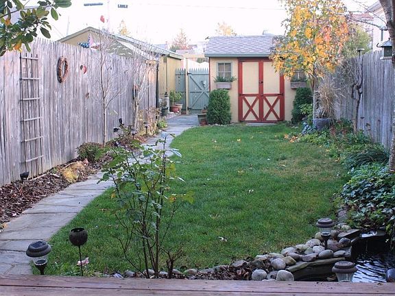 exquisite enclosed rear yard with shed, deck,fish pond, prize plantings