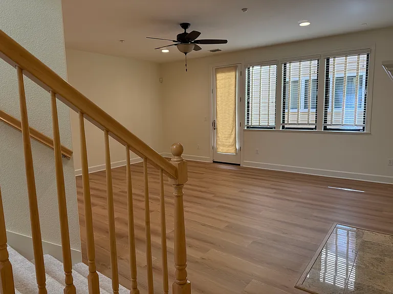 Spacious family room features a gas fireplace, large windows, ceiling fan and a glass patio door that opens to a relaxing private side patio.