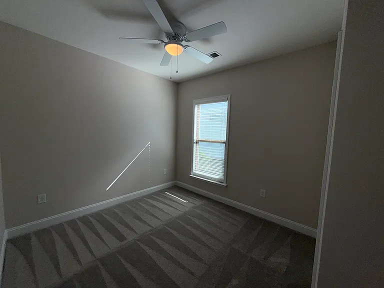 Bedroom 3 with Double Door Closet, Ceiling Fan and Window to side yard. Brand New Carpet and Pad
