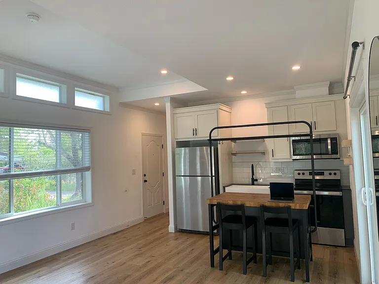 Kitchen, dining, great room all in one. A movable butcher block with shelves and two stools. Arrange the space any way you like.