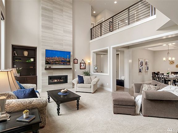 Great room features 20 foot ceilings, wall of windows opens to a tranquil setting, modern fireplace with expansive tile and contemporary open railing! 