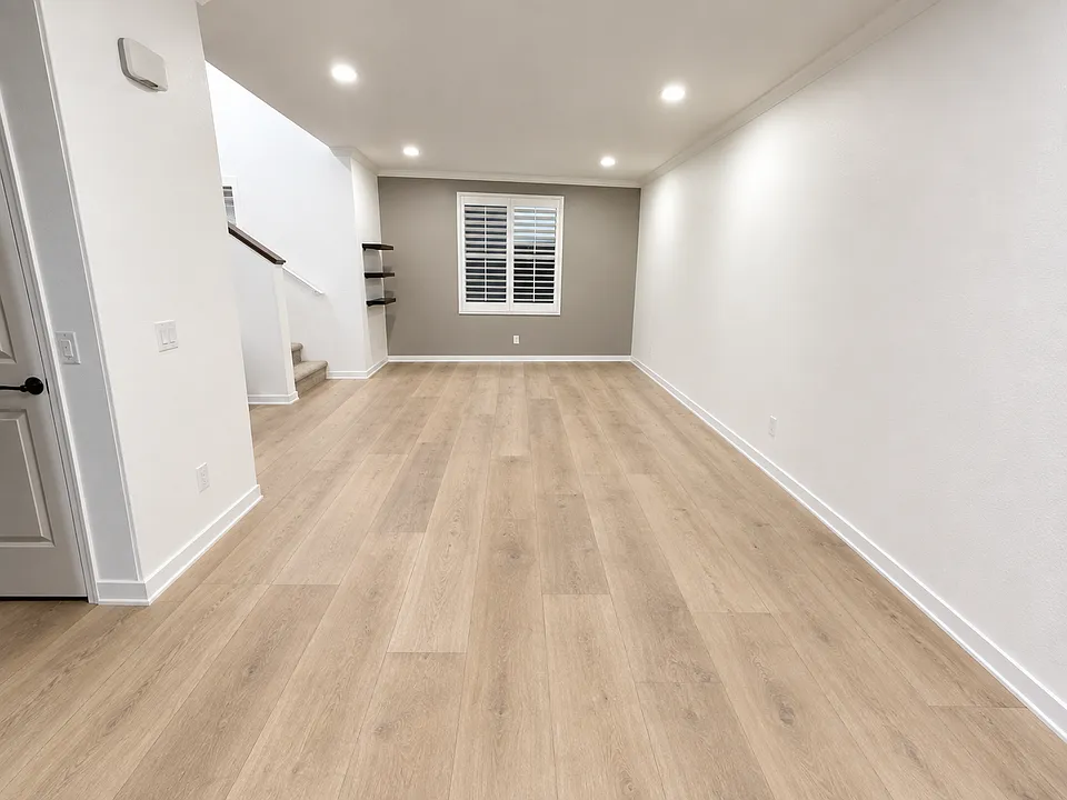 From the kitchen, a spacious, open-concept dining room and living room (virtually staged to reflect updated flooring)