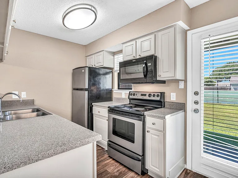 Renovated kitchen with sleek stainless steel appliances, ample cabinet space, and modern finishes.