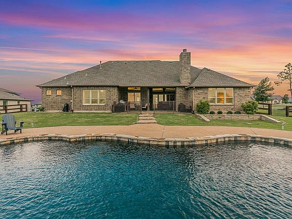 Pool at dusk featuring a lawn
