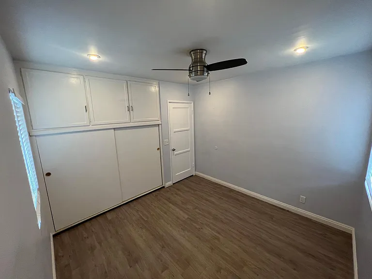 Third bedroom, no carpet, ceiling fan, wall ac unit, built-in storage & closet.