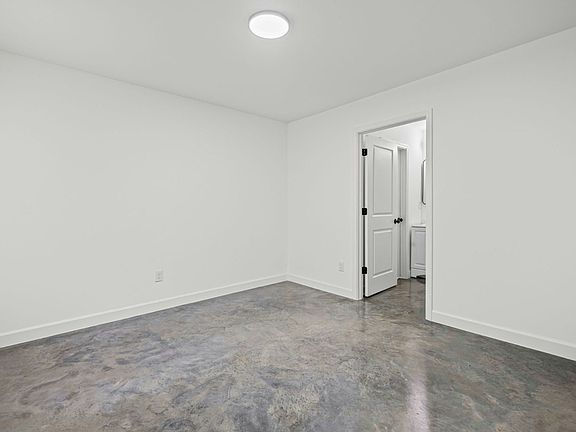 A versatile minimalist space featuring polished concrete floors and a clean, white-walled interior.