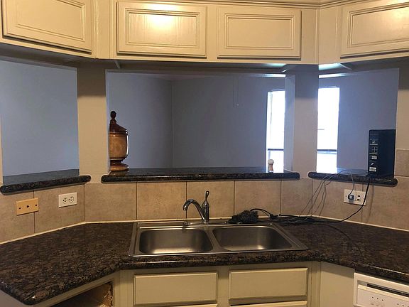 Kitchen features granite countertops with bar seating overlooking the living room.