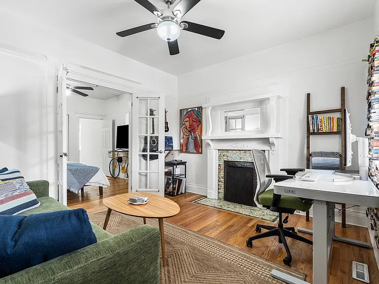 Bright & open living space with a decorative fireplace and custom floor to ceiling library wall __
