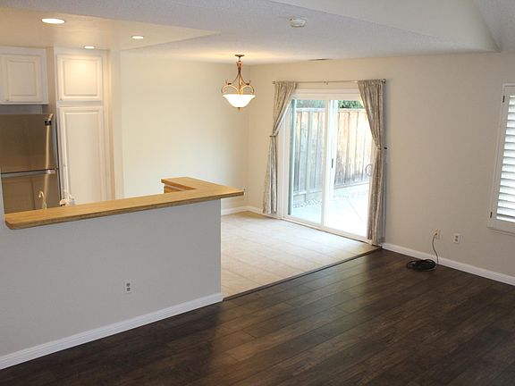 View looking into kitchen area with bright dining area, tiled floors, and new appliances.
