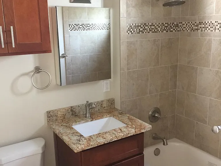 Bathroom with cherry cabinets and granite countertop, tile f