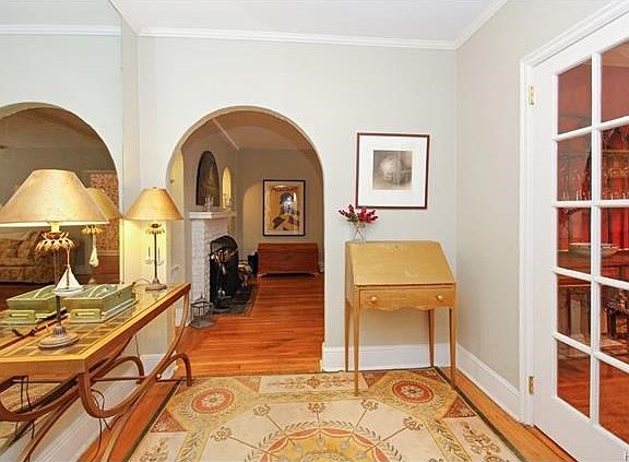 Archway and doorway accent the foyer leading to the living room and dining room.